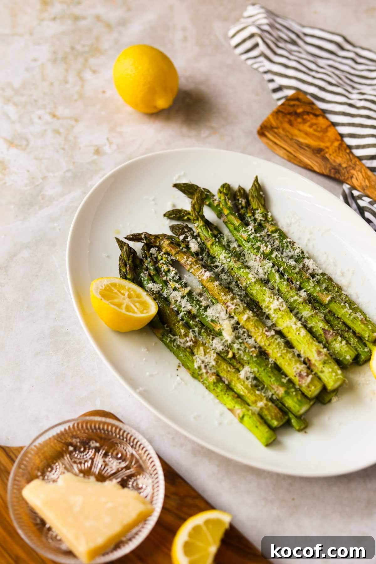 20 Delicious Side Dishes to Serve with Sliders 11 Roasted Asparagus with Parmesan and Lemon on plate.