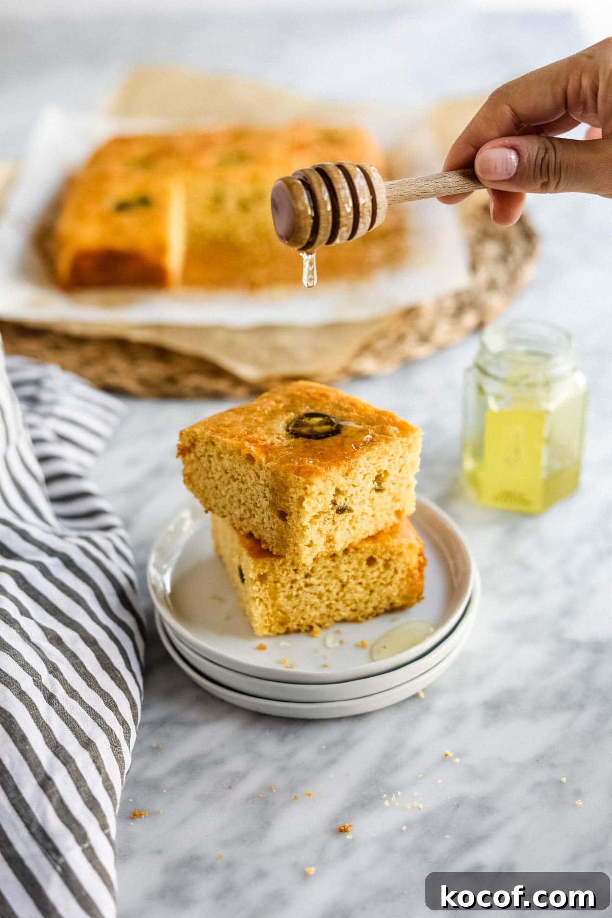 20 Delicious Side Dishes to Serve with Sliders 20 Jalapeño Cheddar Cornbread with Miso sliced on plate with butter and honey.