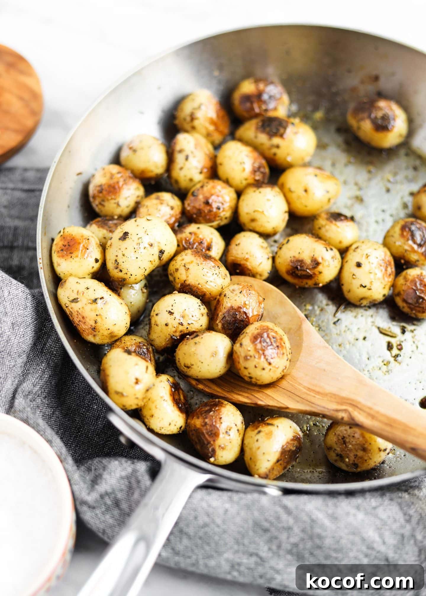 20 Delicious Side Dishes to Serve with Sliders 8 potatoes roasting in a pan with spoon
