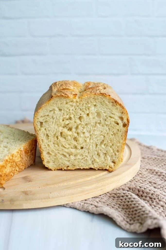 Baking Sourdough in a Loaf Pan: Step-by-Step Guide for Perfect Crust 5 A loaf of sourdough brad has been sliced and sits on a cutting board.