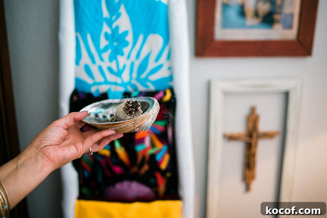 Smudge Your Home for Protection: Simple Ritual and Prayer 5 Yvette Marquez holding an abalone shell filled with a smoking smudge stick to smudge her home.