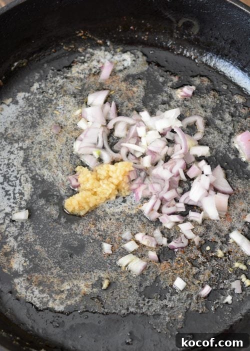 Creamy One-Pan Pork Chops with Garlic Herb Sauce 5 chopped shallots and garlic sauteeing in butter in a cast iron pan