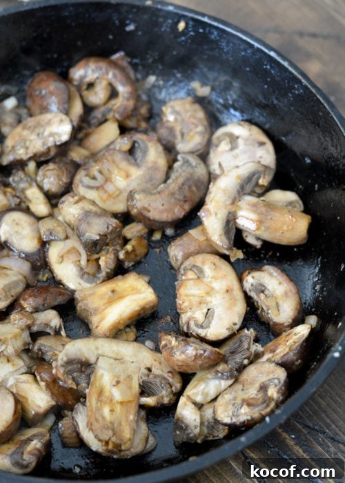 Creamy One-Pan Pork Chops with Garlic Herb Sauce 6 cremini mushrooms cooking in a skillet