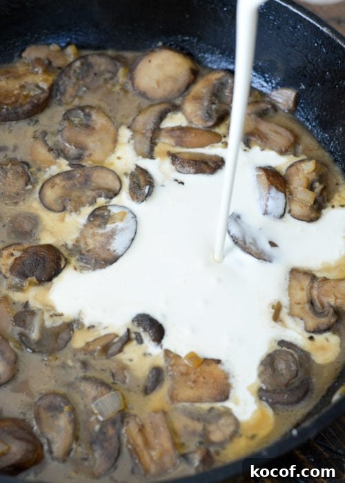Creamy One-Pan Pork Chops with Garlic Herb Sauce 8 heavy cream being poured into a pan sauce with mushrooms, garlic, and shallots