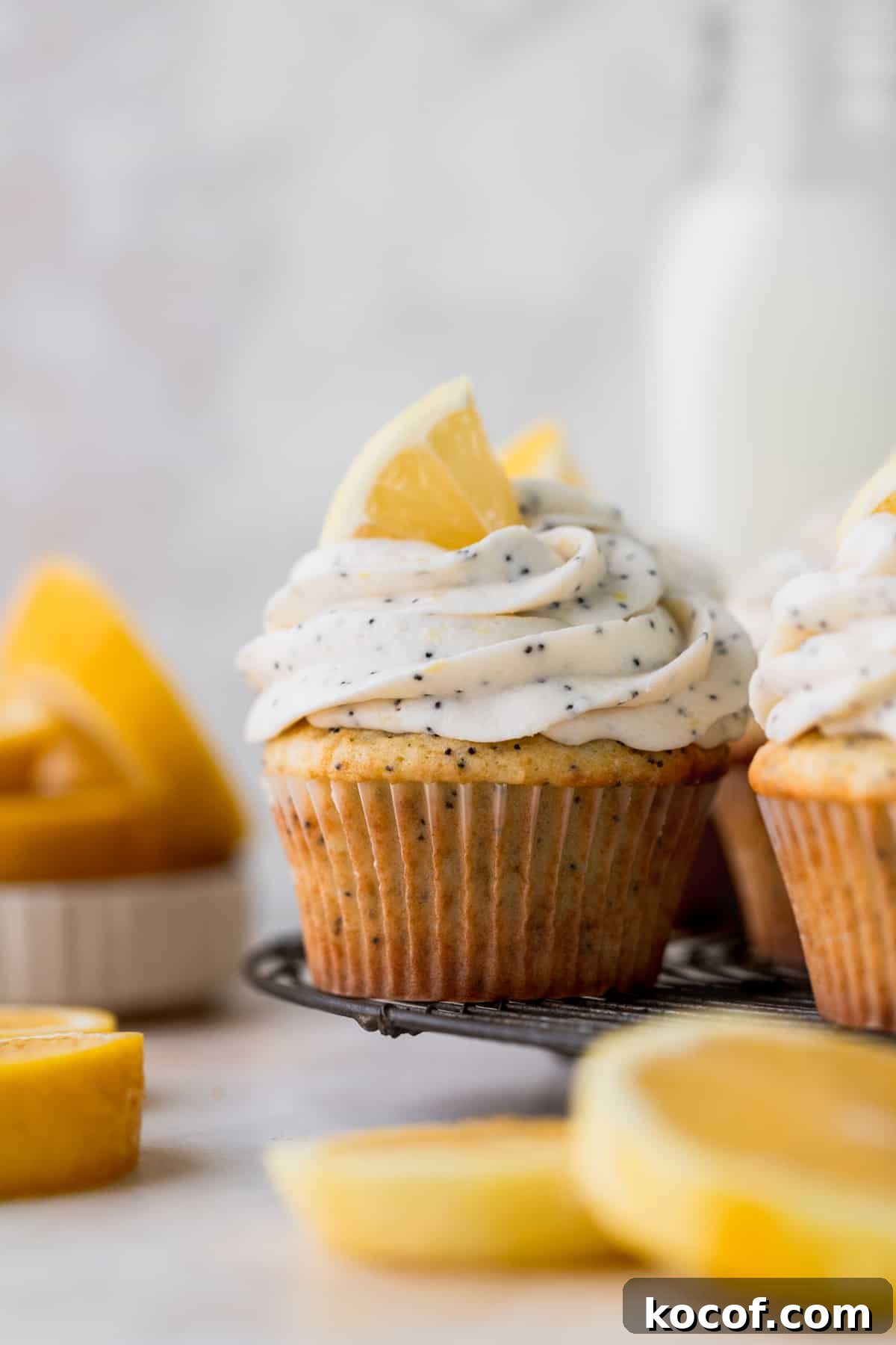 Lemon Poppy Seed Cupcakes with Zesty Glaze and Moist Crumb 9 Lemon poppy seed cupcakes on a wire rack.