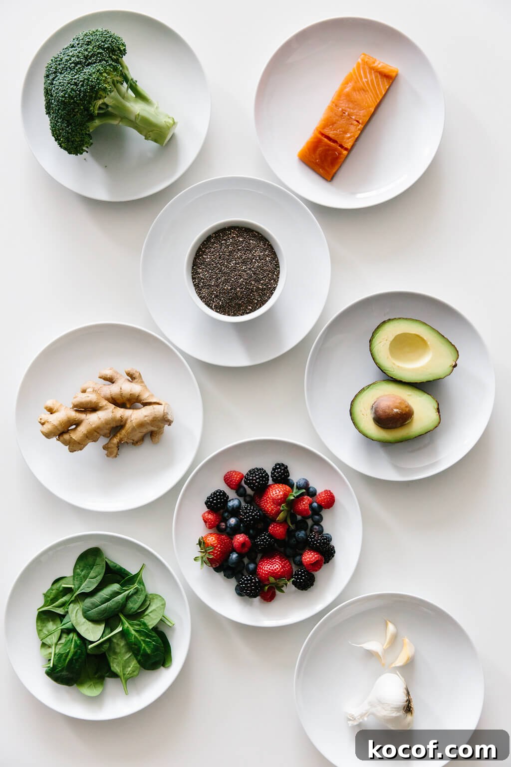 Eight plates of individual anti-inflammatory ingredients on white table. 
