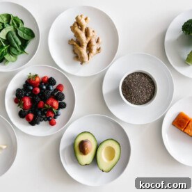 Eight plates of individual anti-inflammatory ingredients on white table.