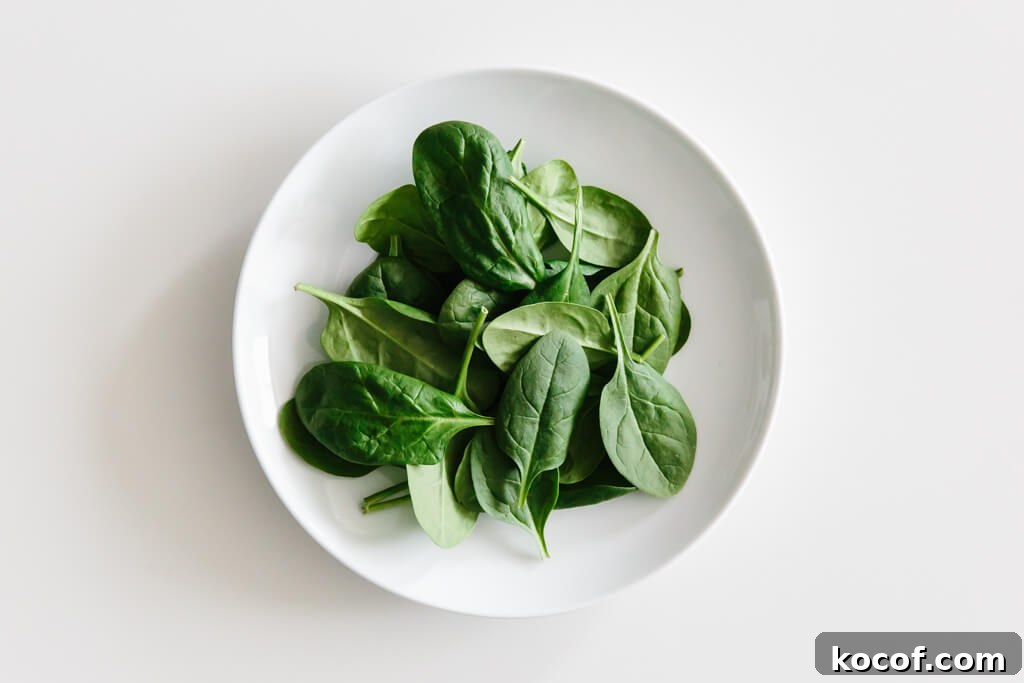 Plate of spinach on a white table.