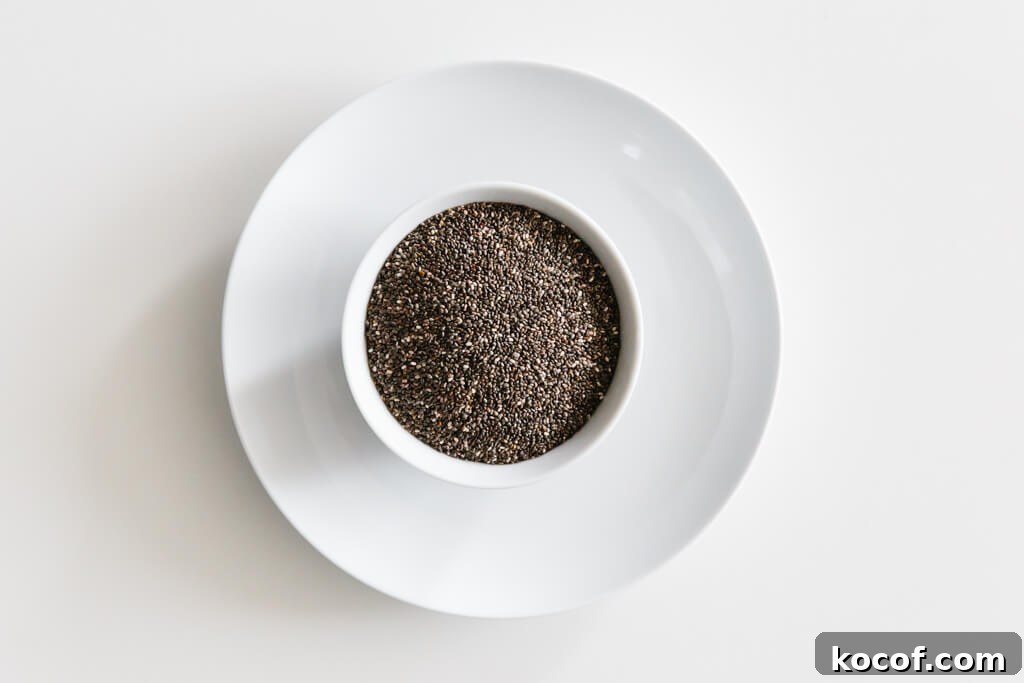 Bowl of chia seeds on a white table.