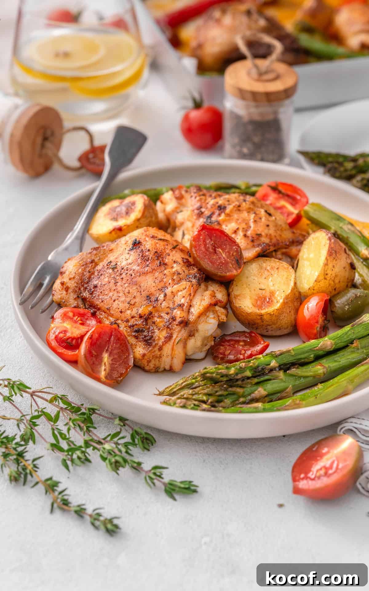 Crispy Herb-Roasted Chicken Thigh Tray Bake with Vegetables 9 Chicken and vegetables served on a plate.