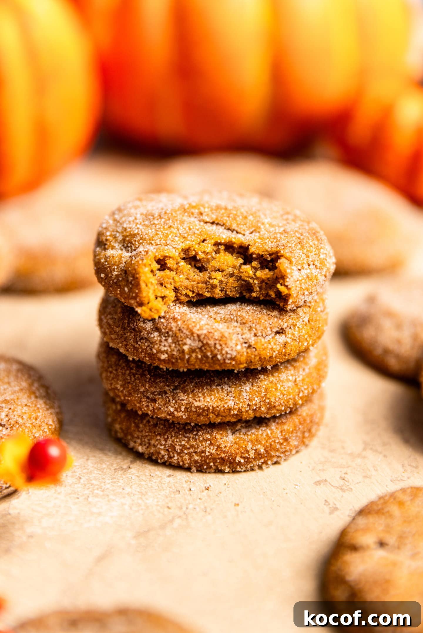 Brown Butter Pumpkin Snickerdoodle Cookies — Soft & Chewy 2 A stack of pumpkin snickerdoodles with a bite missing from the top cookie.