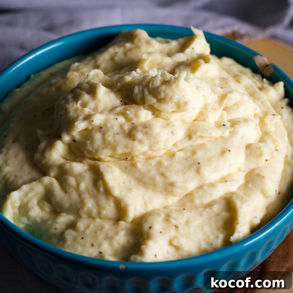 A blue bowl filled with cream cheese mashed potatoes.