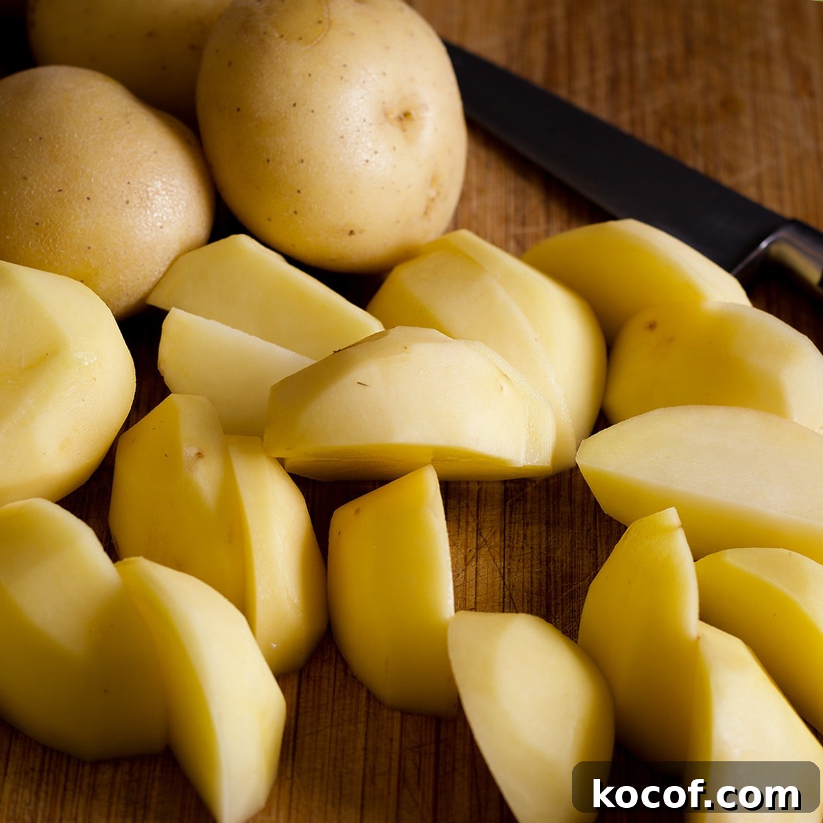 Chopped potatoes on a cutting board with a knife.