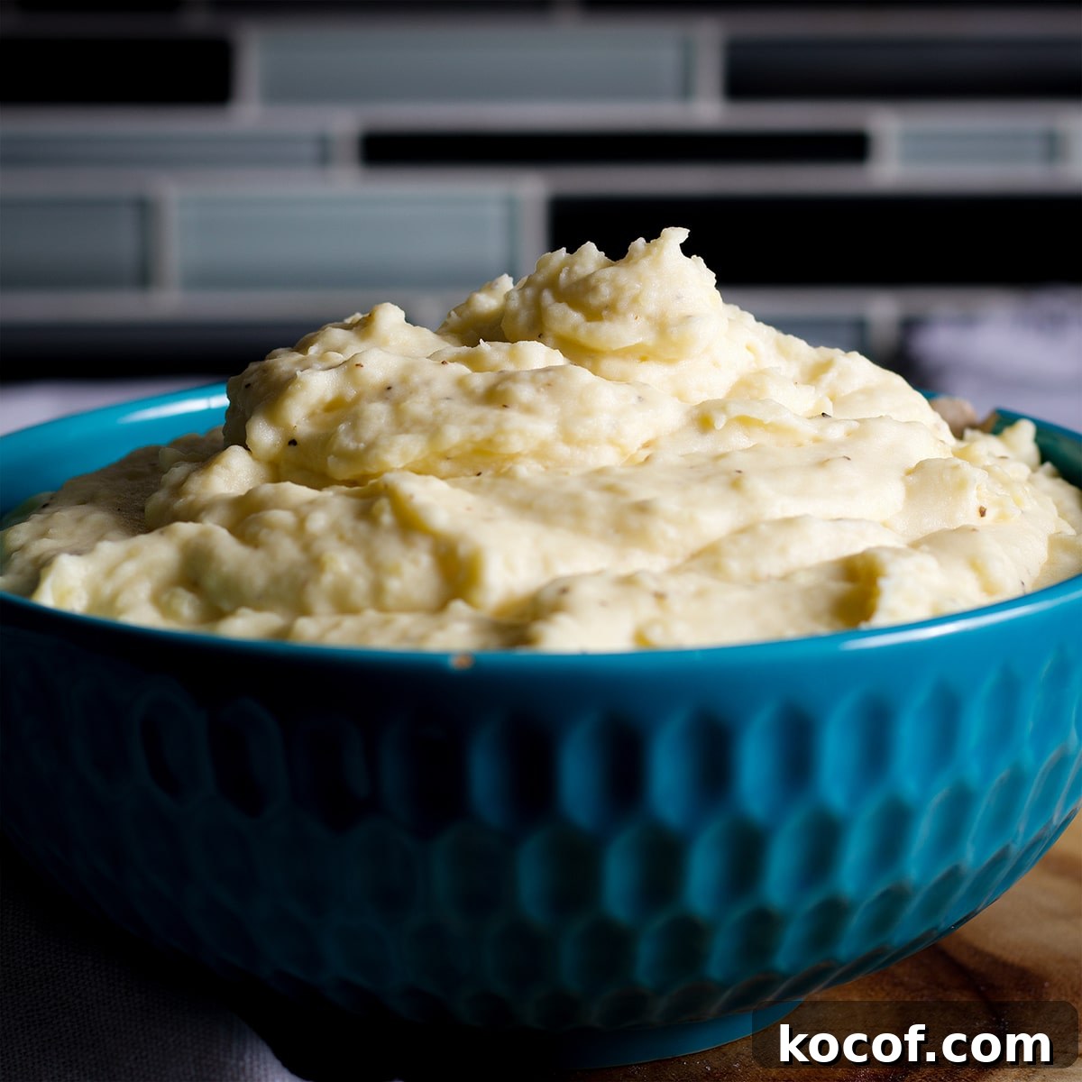 A blue bowl filled with cream cheese mashed potatoes.
