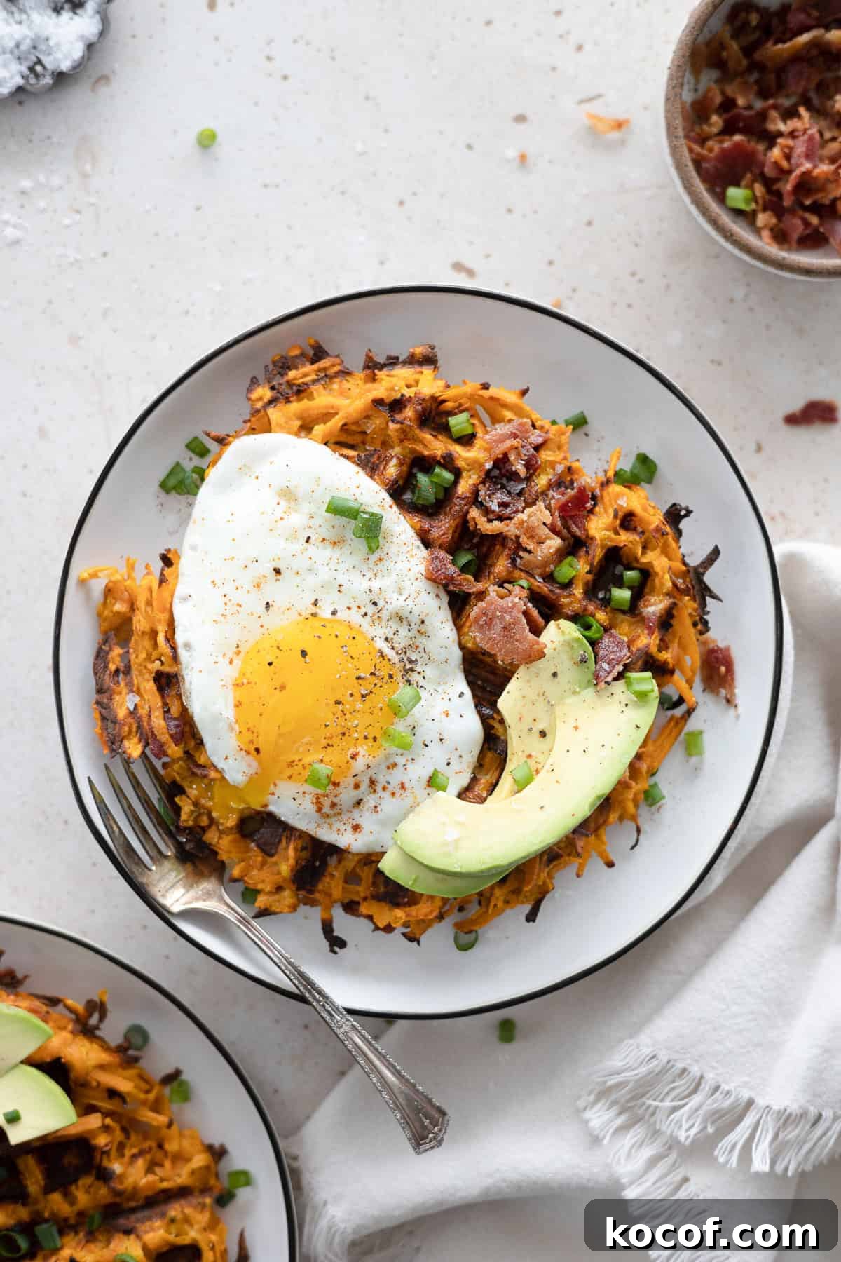 Savory Sweet Potato Waffles with Herbed Yogurt Topping 2 Savory Sweet Potato Waffles topped with egg and avocado.