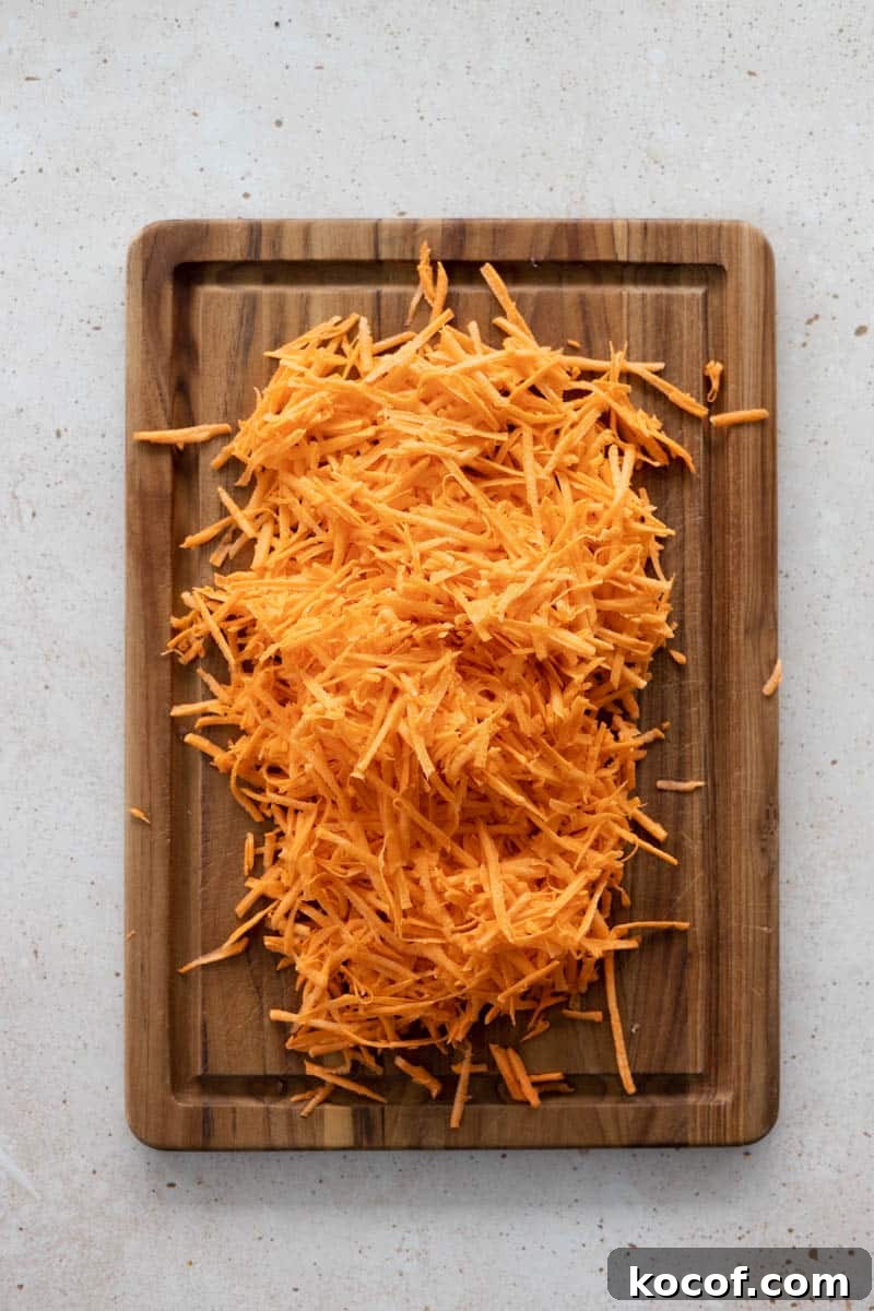 Savory Sweet Potato Waffles with Herbed Yogurt Topping 4 Grated sweet potato on a wooden cutting board from overhead.