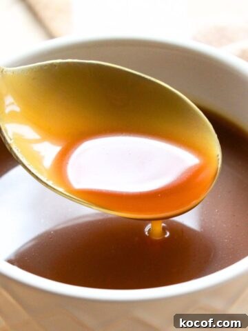 Holding up a spoonful of caramel from a bowl.
