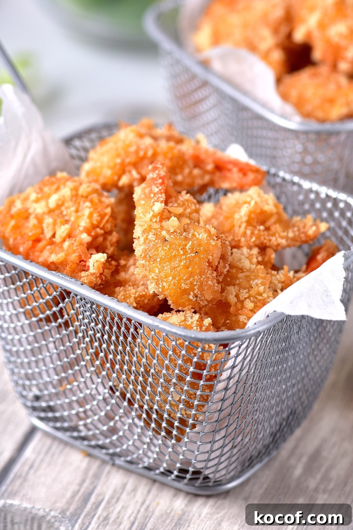 GF Coconut Shrimp Recipe (Dairy-Free) Up close shot of coconut shrimp in metal basket.