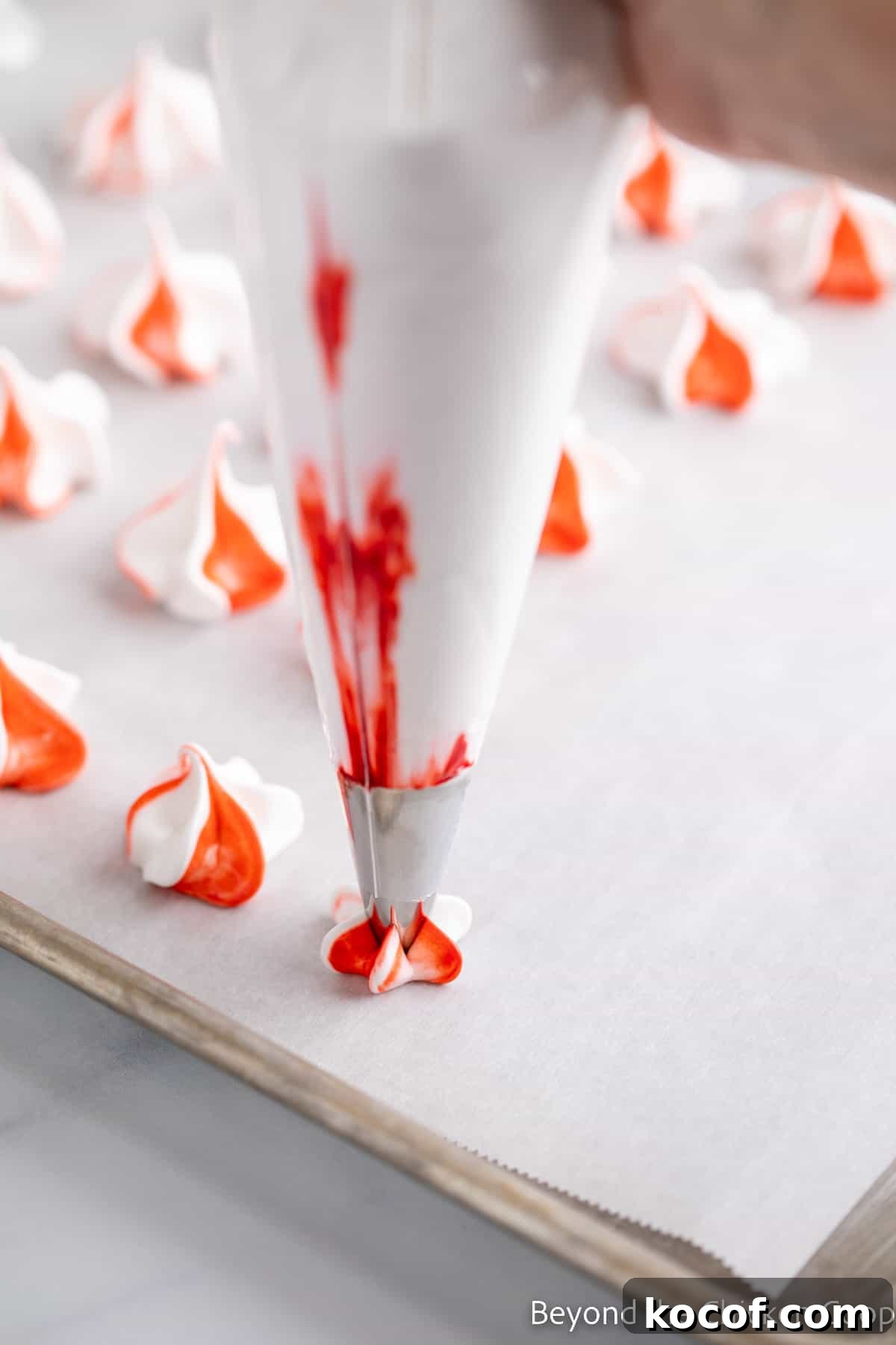 Piping a meringue kiss onto a baking sheet.