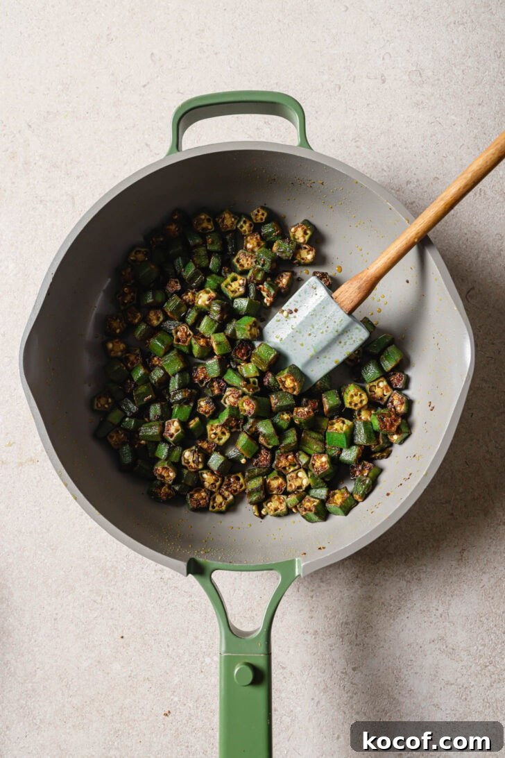 Bhindi Fry in a skillet with a spatula.
