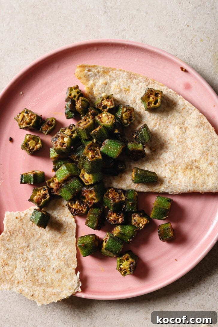Partially eaten plate of Bhindi Fry with roti.