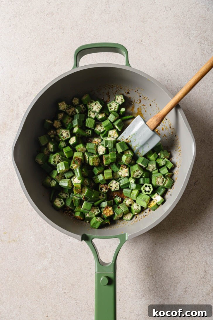 Sliced okra added to skillet.