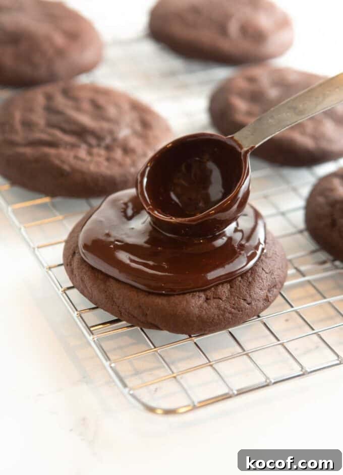 Fudgy Peppermint Brownie Cookie Recipe 11 spoon spreading chocolate mint ganache on cookie