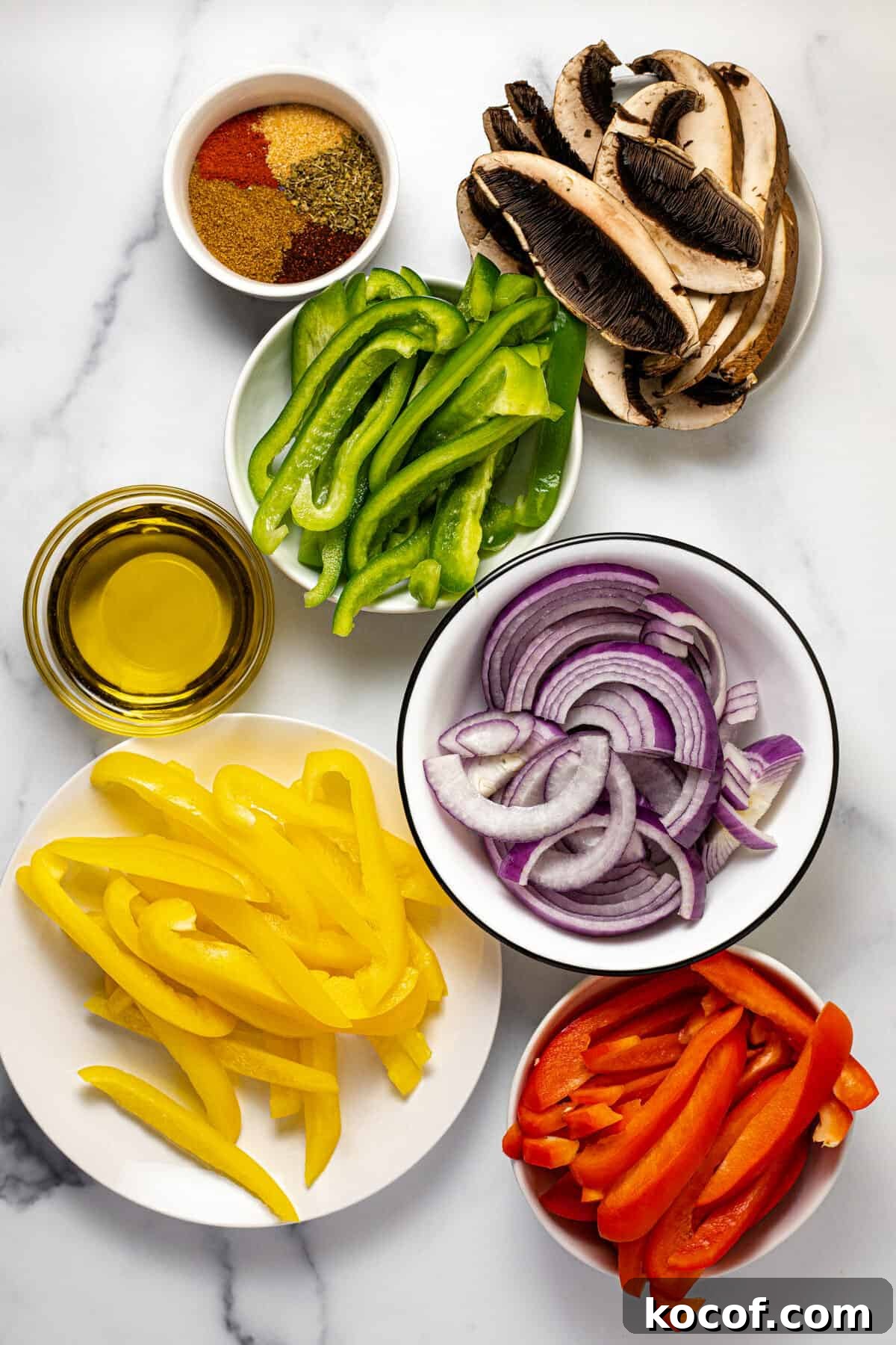 White marble countertop with bowls of ingredients to make fajita veggies