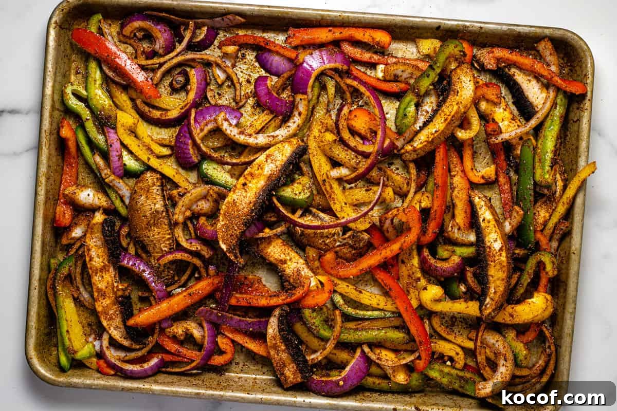 Baking sheet filled with fajita veggies ready to go in the oven