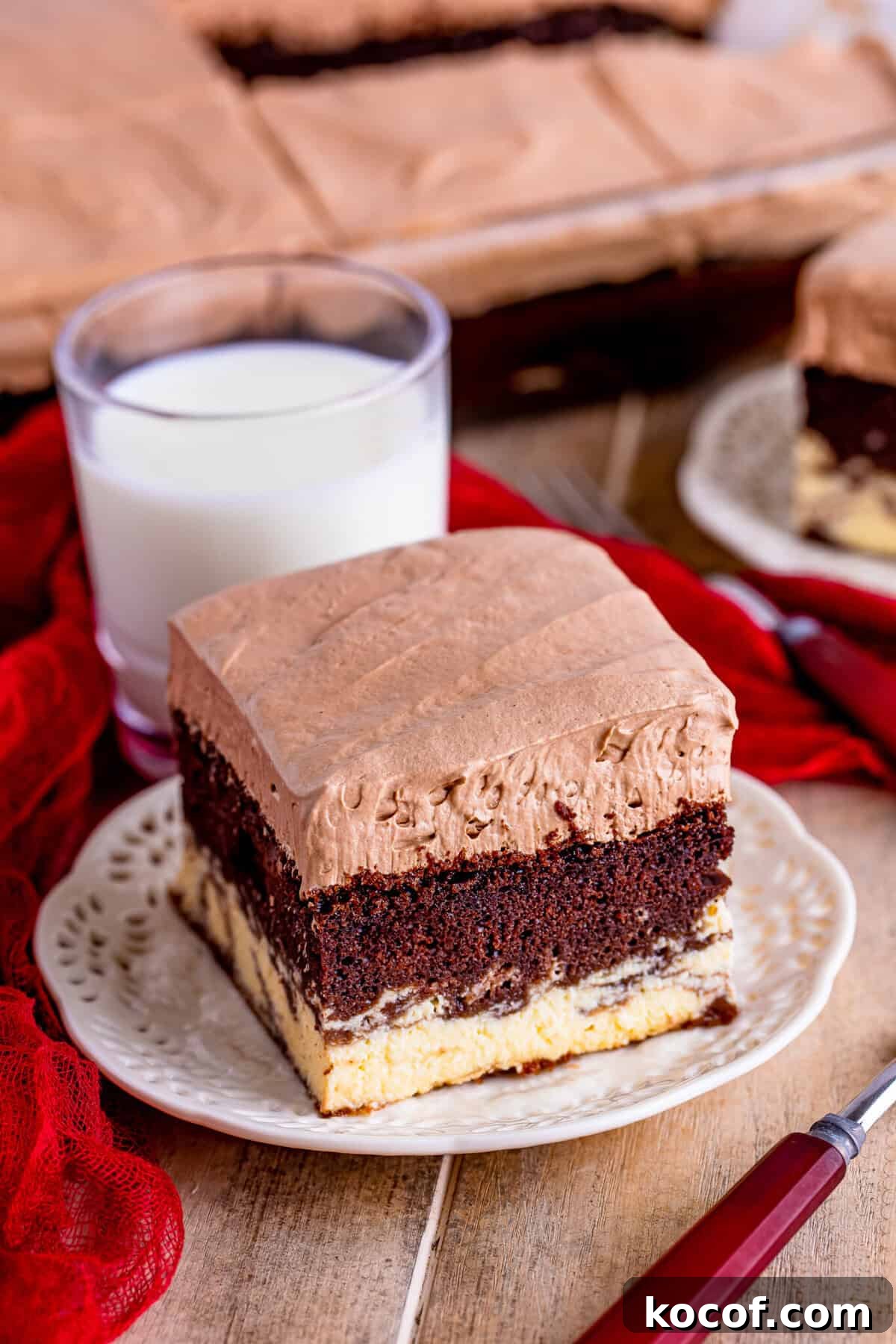 A slice of Italian Love Cake Recipe served on a white plate showing the layered fudgy chocolate cake, sweet ricotta filling, and rich chocolate pudding topping.