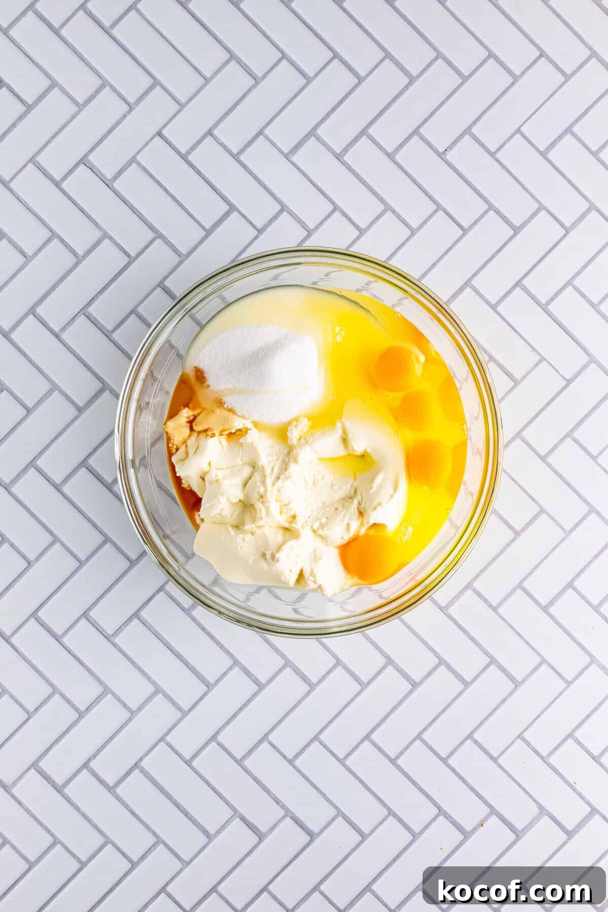 Ricotta cheese, eggs, sugar, and vanilla mixed in a glass bowl for the Italian Love Cake Recipe filling.