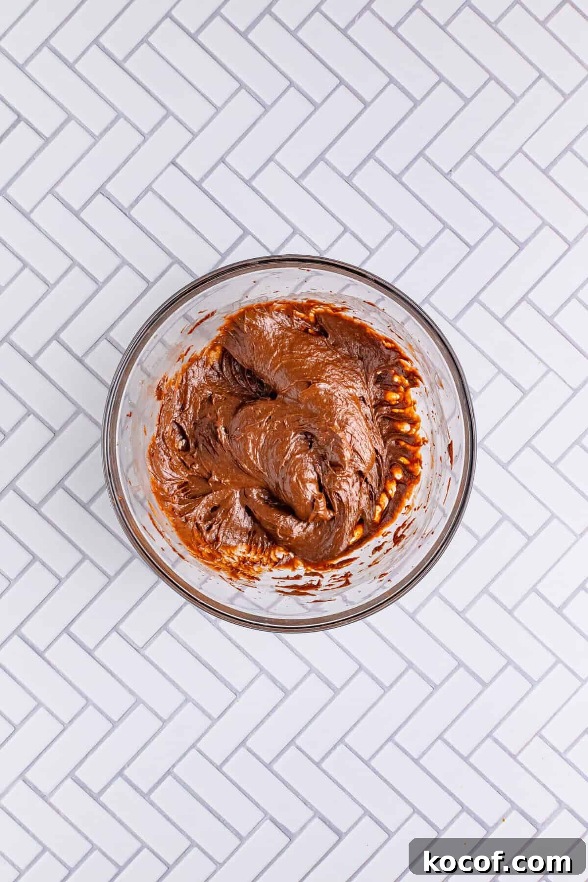 Cold milk and instant chocolate pudding mix being whisked together in a large bowl for the Italian Love Cake Recipe topping.