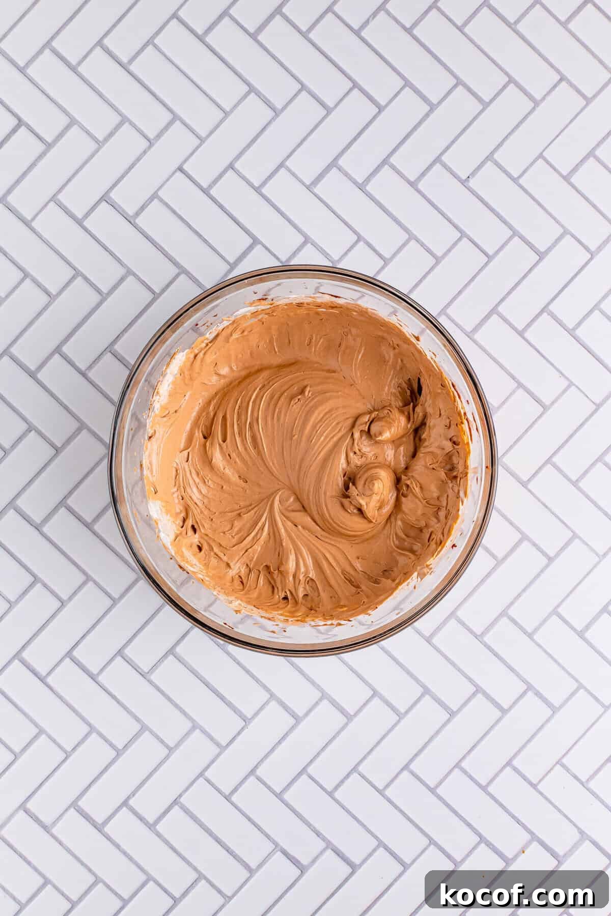 Whipped topping being folded into chocolate pudding mixture for the Italian Love Cake Recipe topping layer.
