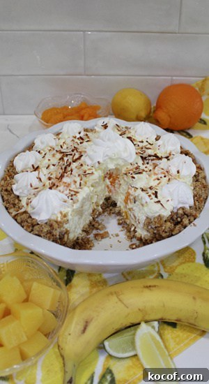 Inside of a pie showing chunks of tropical fruit like pineapple and mandarin orange.