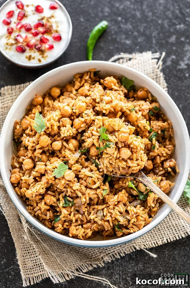 Instant Pot Brown Rice Chana Pulao Recipe 7 a long spoon scooping out chana pulao from a bowl