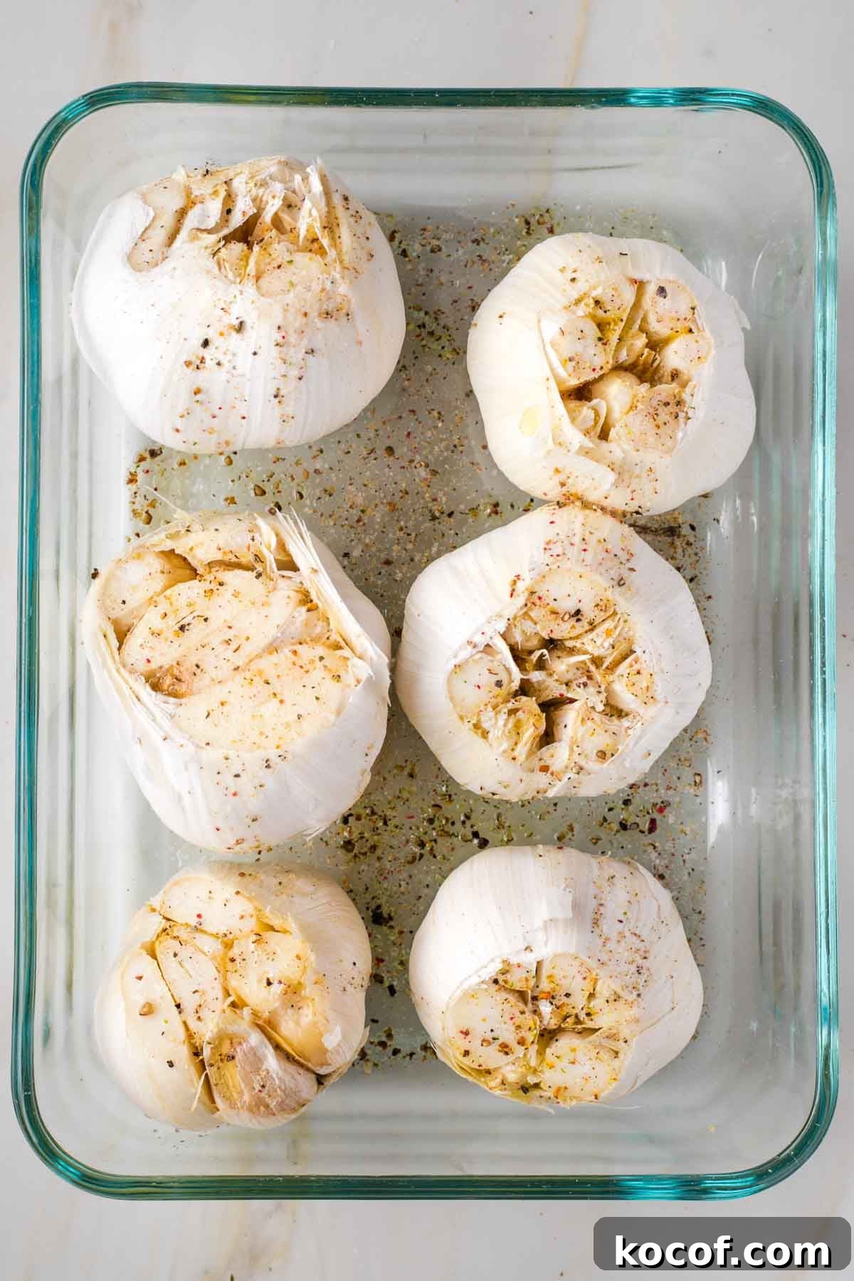 Oven-Roasted Garlic Bulbs: Crispy, Sweet Garlic Recipe 5 6 whole heads of garlic in a baking dish, drizzled with oil and sprinkled with salt and pepper.