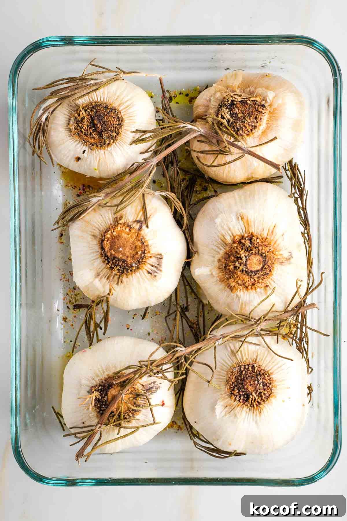 Oven-Roasted Garlic Bulbs: Crispy, Sweet Garlic Recipe 8 Garlic bulbs, roasted in a baking dish with fresh rosemary.