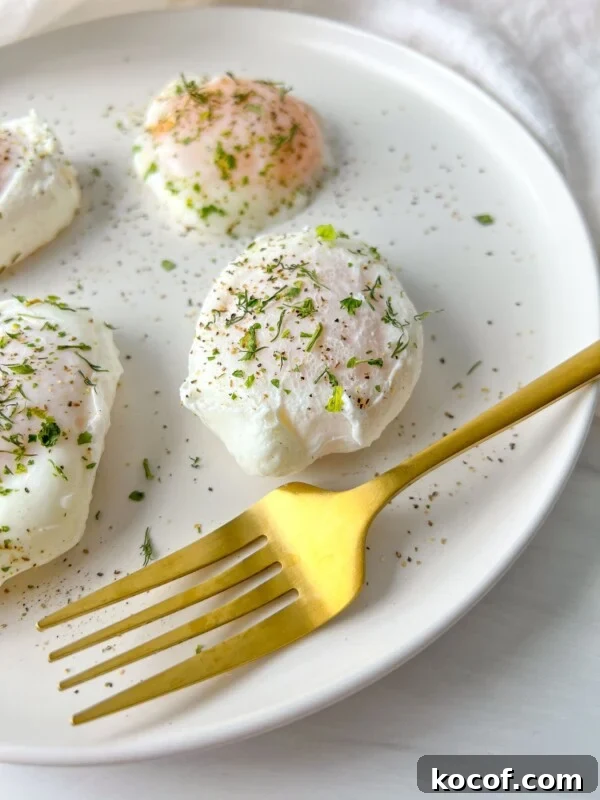 Perfect Hard-Boiled Eggs in the Air Fryer: Quick Guide 5 A white plate with three poached eggs sprinkled with herbs and black pepper sits next to a gold fork.