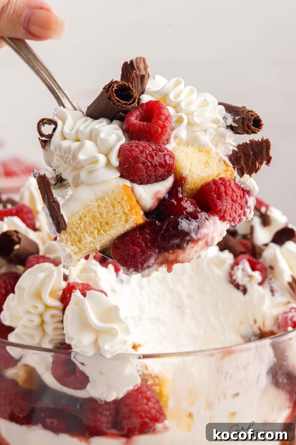 Decadent Raspberry Trifle Recipe with Layers of Cream and Cake 12 Close up of Raspberry Trifle with a spoon inserted.