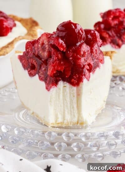 A slice of Raspberry Cream Cheese Pie on a plate with a fork mark taking out.