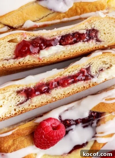 Raspberry cream cheese danish braid cut into several pieces to show the insides.