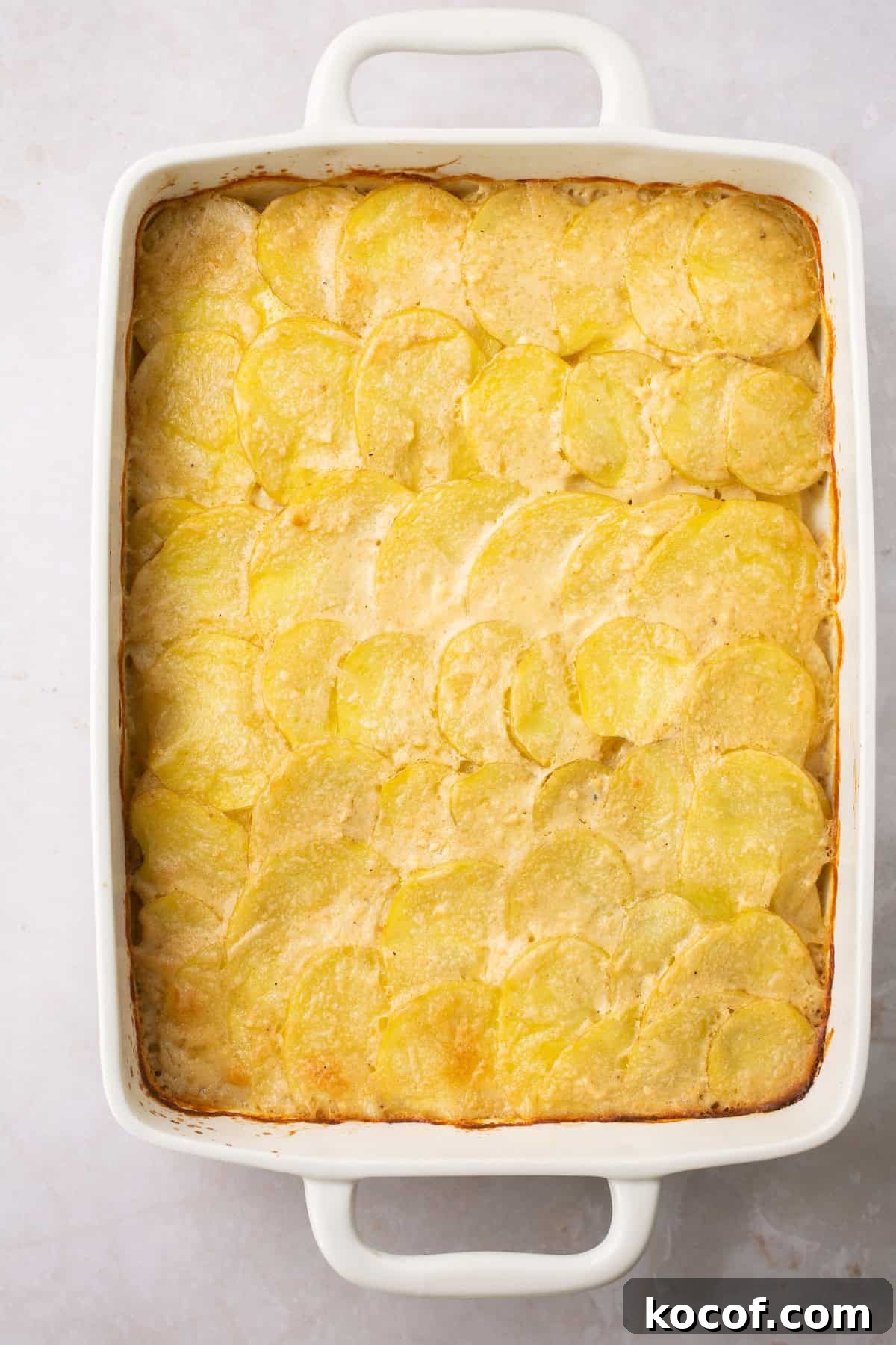 an overhead shot of gluten free scalloped potatoes in a white baking dish. 
