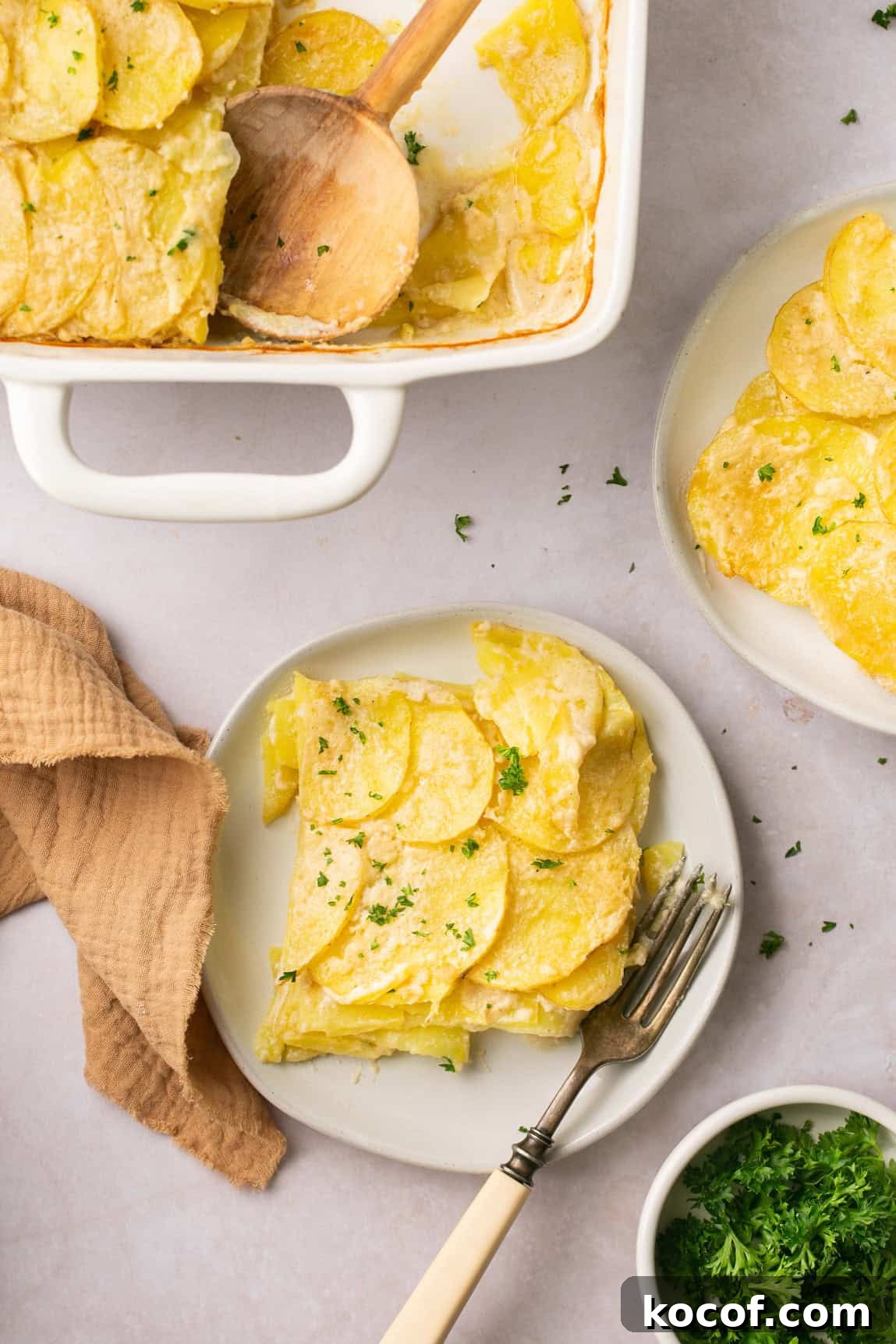 a serving of scalloped potatoes on a plate with a fork resting on the side