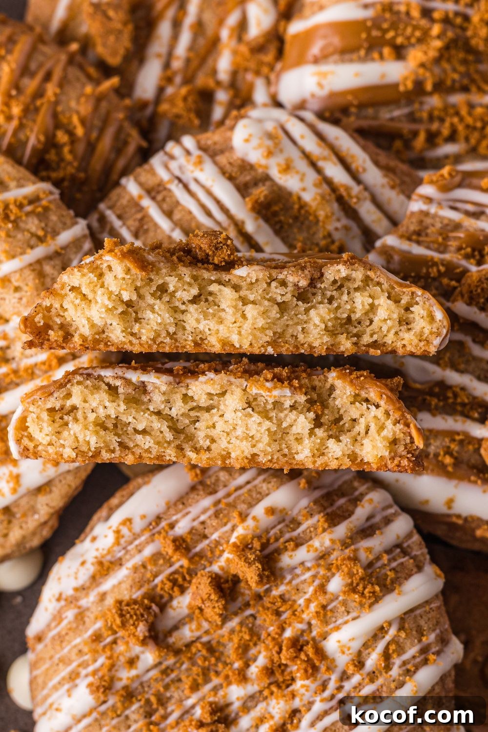 Biscoff Snickerdoodle Cookies spread around the table with one cookie broken in half to show the center of cookies 