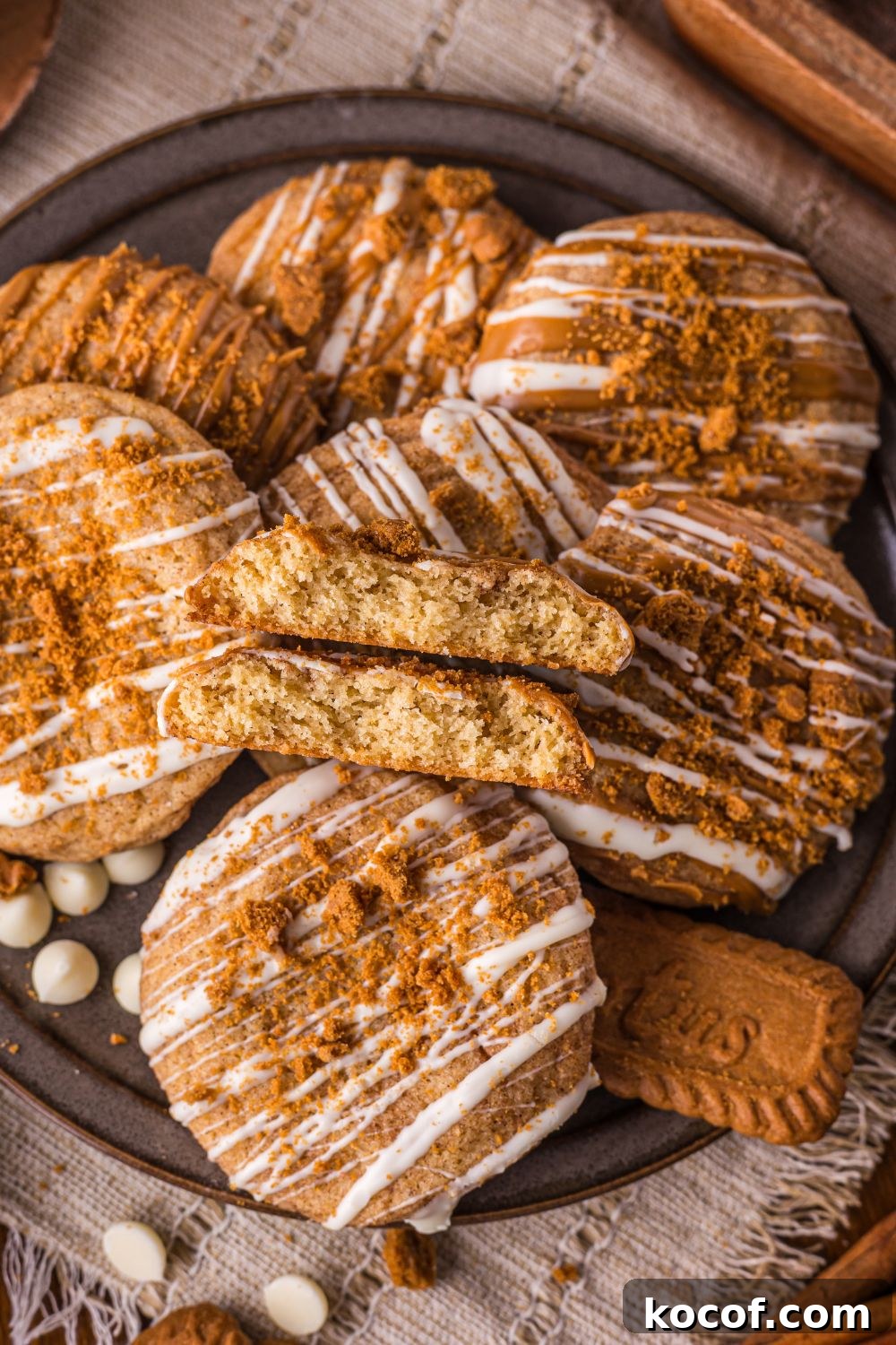 Biscoff Snickerdoodle Cookies on a round plate on table with Biscoff cookies, white chocolate, and more around the tray 