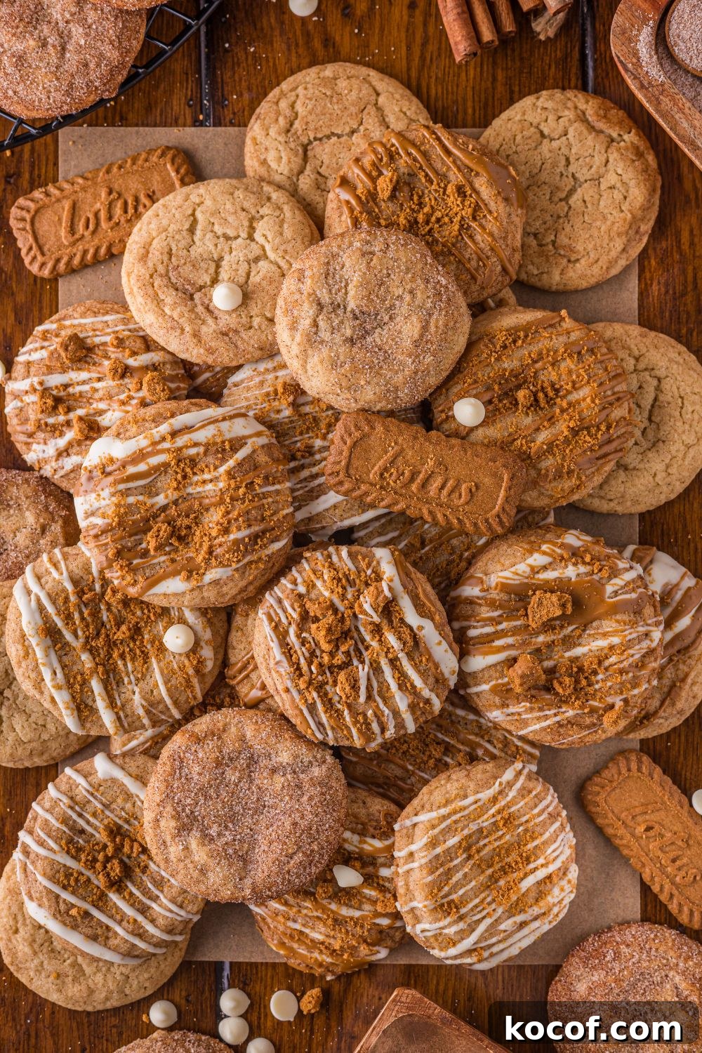 Biscoff Snickerdoodle Cookies piled on the table with white chocolate chips around the table 