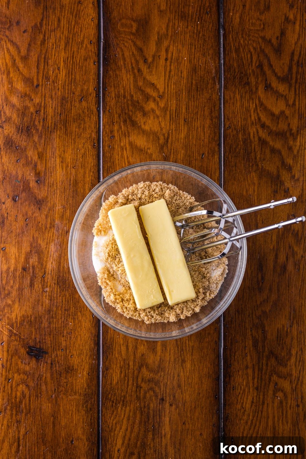 brown sugar and two sticks of butter with a glass bowl 
