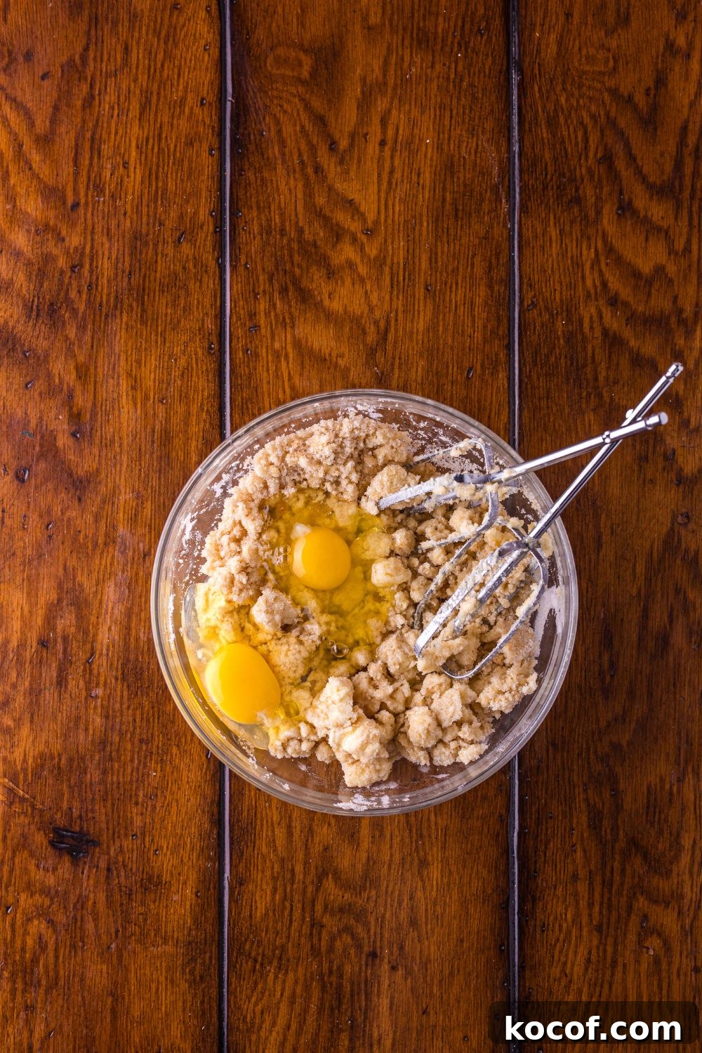 Biscoff Snickerdoodle Cookies dough in a glass bowl with mixers to side 