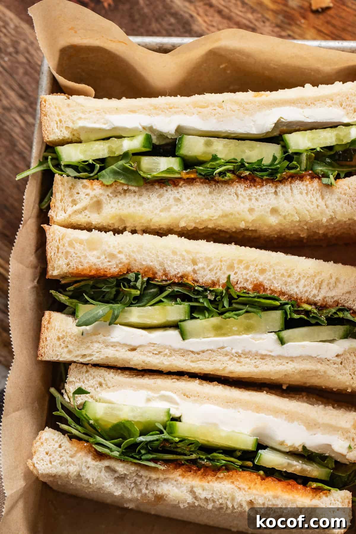Vegetable sandwiches stacked in a box.