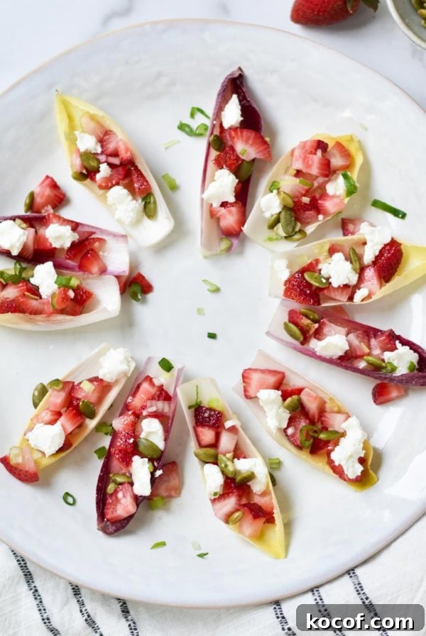Endive appetizer next to green onion, pepitas, and strawberries.